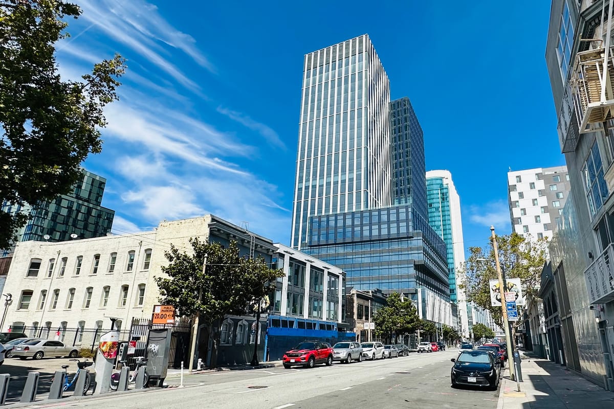 A wide SoMa street in San Francisco looking toward the district's modern high-rise towers, with low-rise buildings in the foreground.